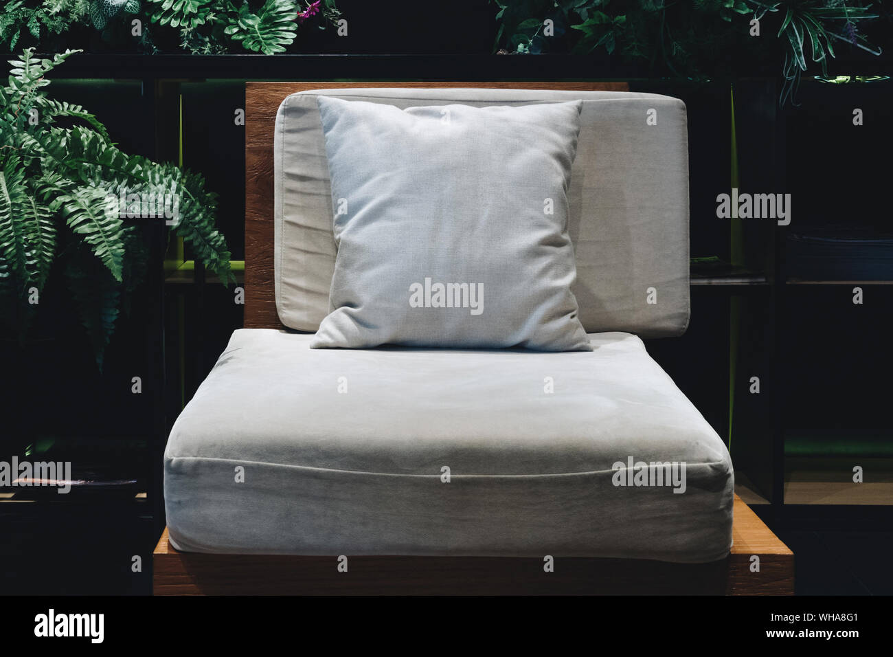 Comfort chaise en bois avec coussin et oreillers en coton doux en basse lumière prêt à se reposer dans le jardin de style de décoration salon. Meubles Décoration un Banque D'Images