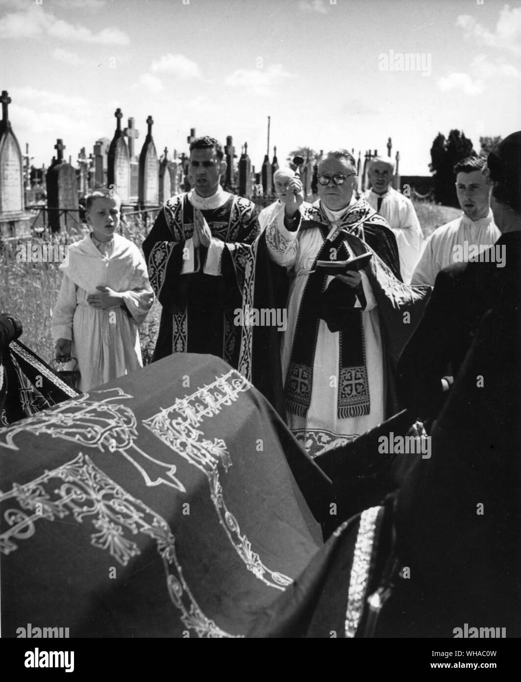 Funérailles. Le cercueil et graves sont aspergés d'eau bénite et le prêtre prie sur la tombe Banque D'Images Funérailles. Le cercueil et graves sont aspergés d'eau bénite et le prêtre prie sur la tombe Banque D'Images