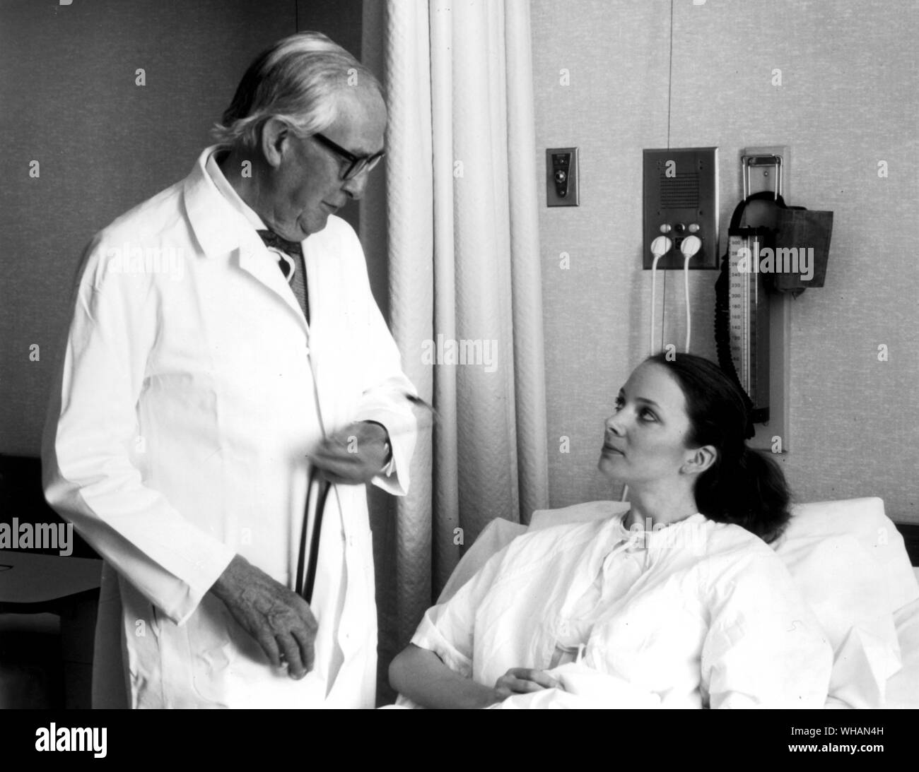 Femme dans un lit d'hôpital, de parler au médecin Banque D'Images