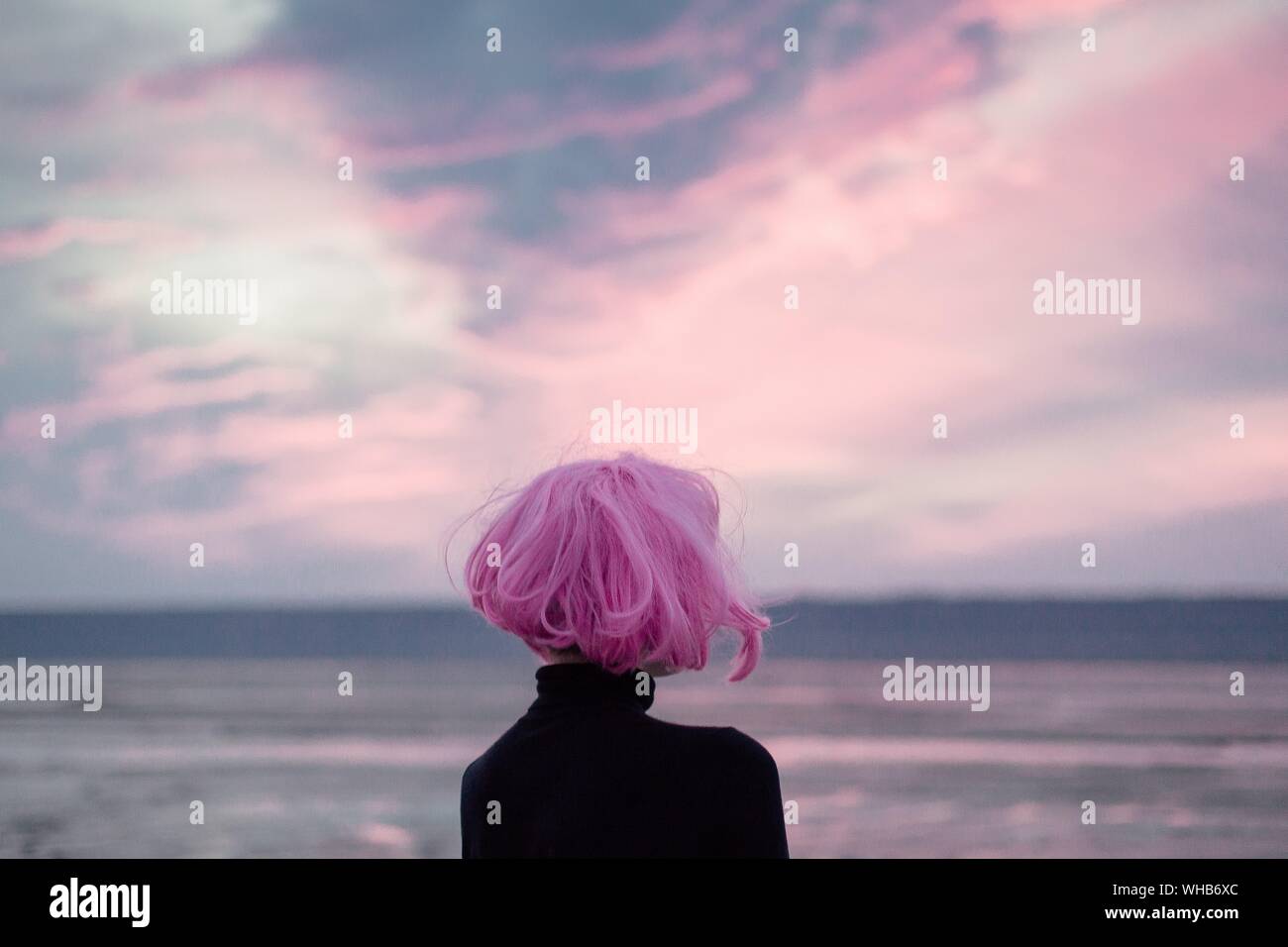 Femme Avec les cheveux roses à la Sky pendant le coucher du soleil Banque D'Images