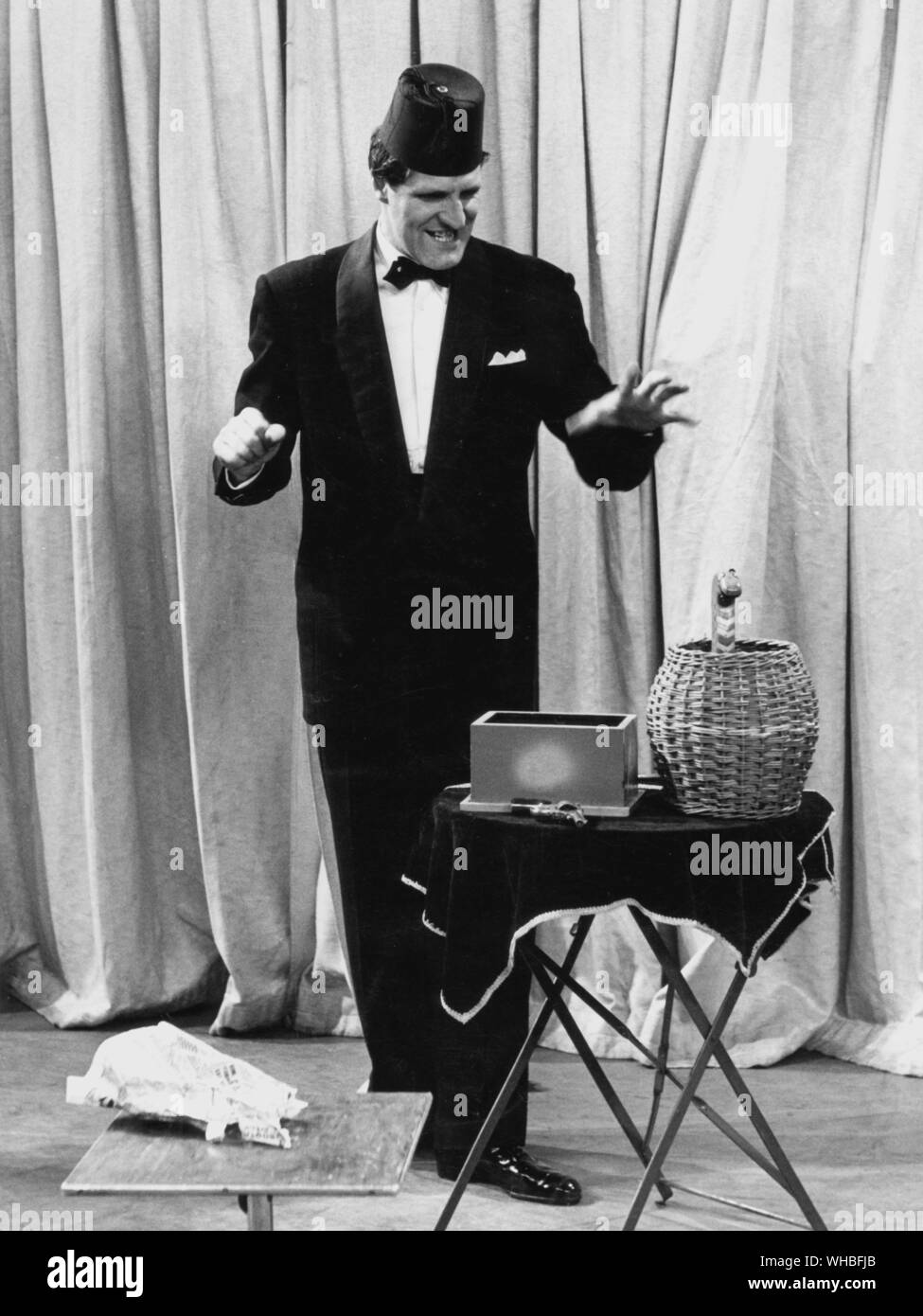 Tommy Cooper le comédien qui est presque un magicien réussit à fabriquer un serpent de son panier de serpents Banque D'Images