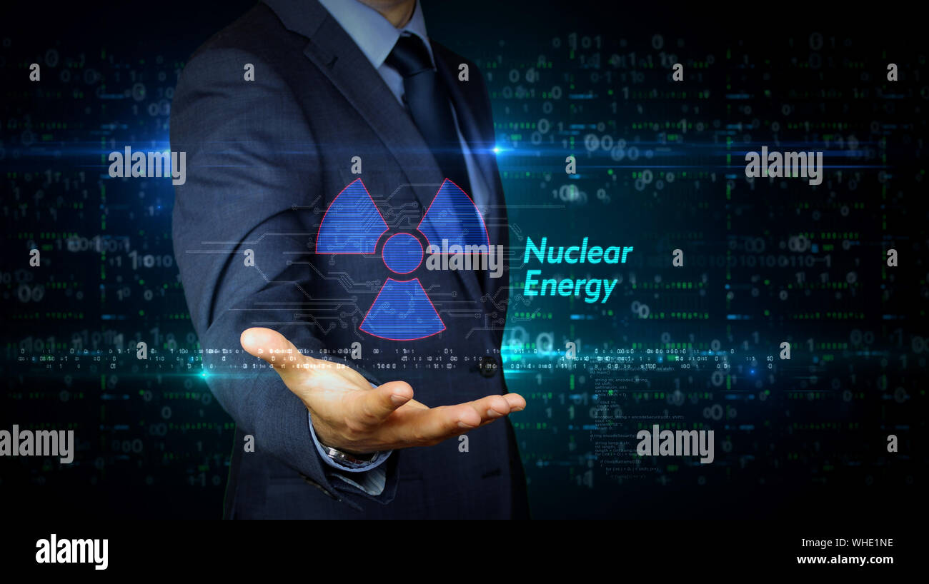 Un homme en costume écran tactile avec symbole de l'énergie nucléaire hologramme. L'homme à l'aide de main sur l'interface d'affichage virtuel. La science, l'icône de danger et cyber Banque D'Images