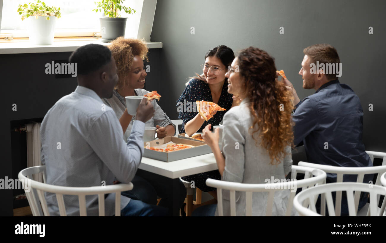 Heureux les gens d'affaires de bureau multi-ethnique s'amusant partager ensemble pizza Banque D'Images