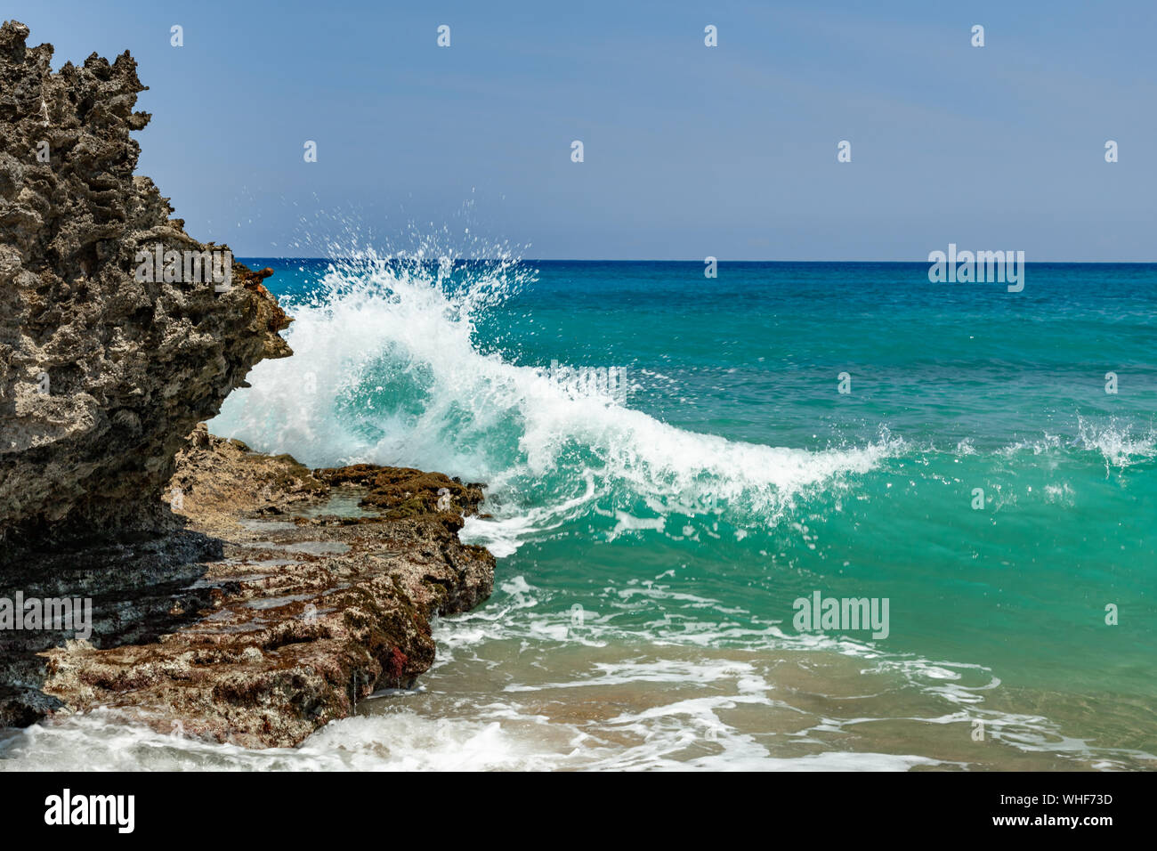 Les vagues écumeuses de l'océan, des éclaboussures sur la plage à proximité de rochers Banque D'Images