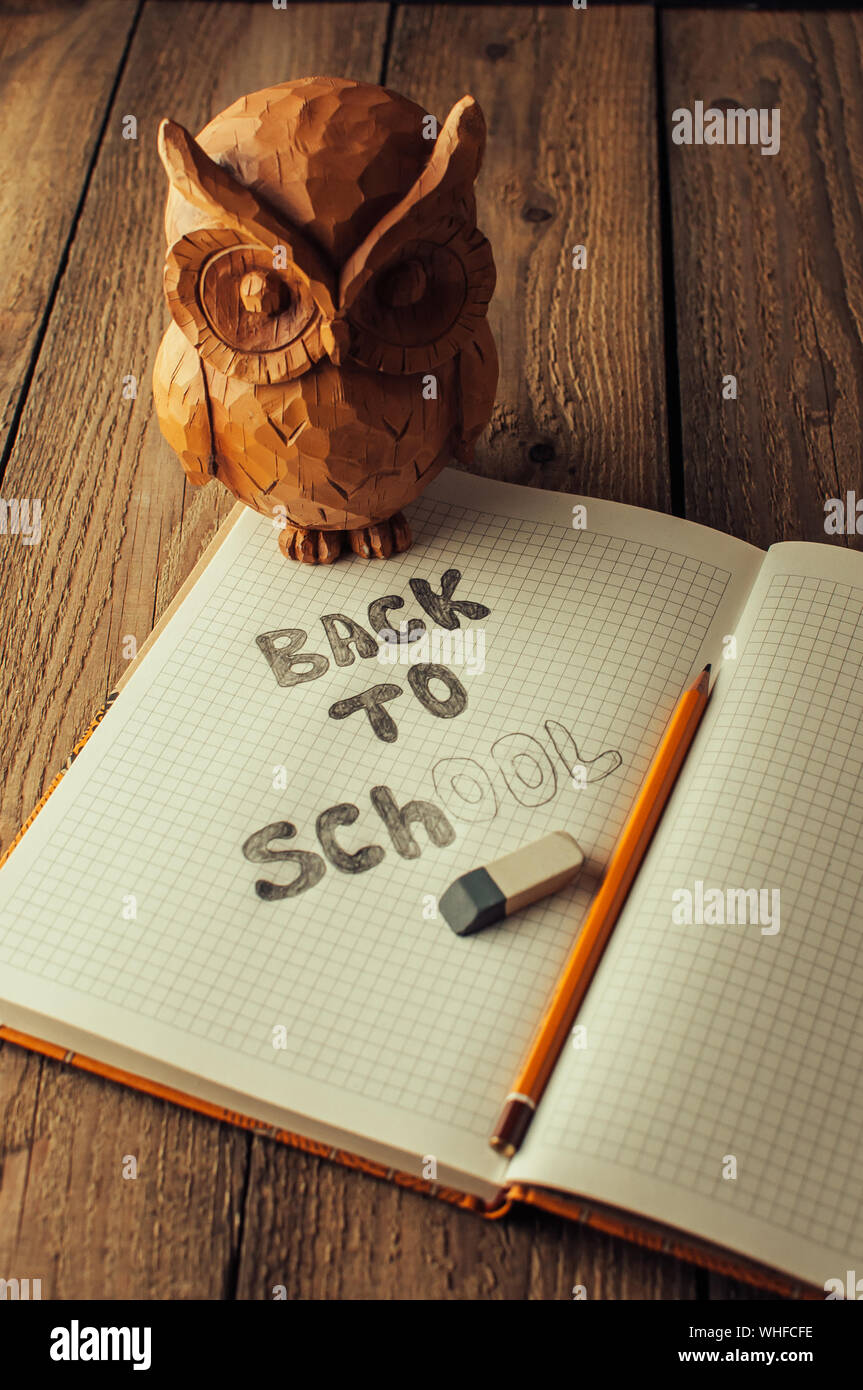 Retour à l'école, la notion de parent. Owl sur une table en bois. L'inscription sur la craie de couleur ardoise. Fournitures scolaires, rustique. Banque D'Images