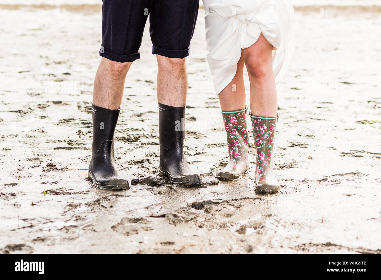La section basse de l'homme et de la femme portant des bottes en  caoutchouc, tandis que la boue permanent Photo Stock - Alamy