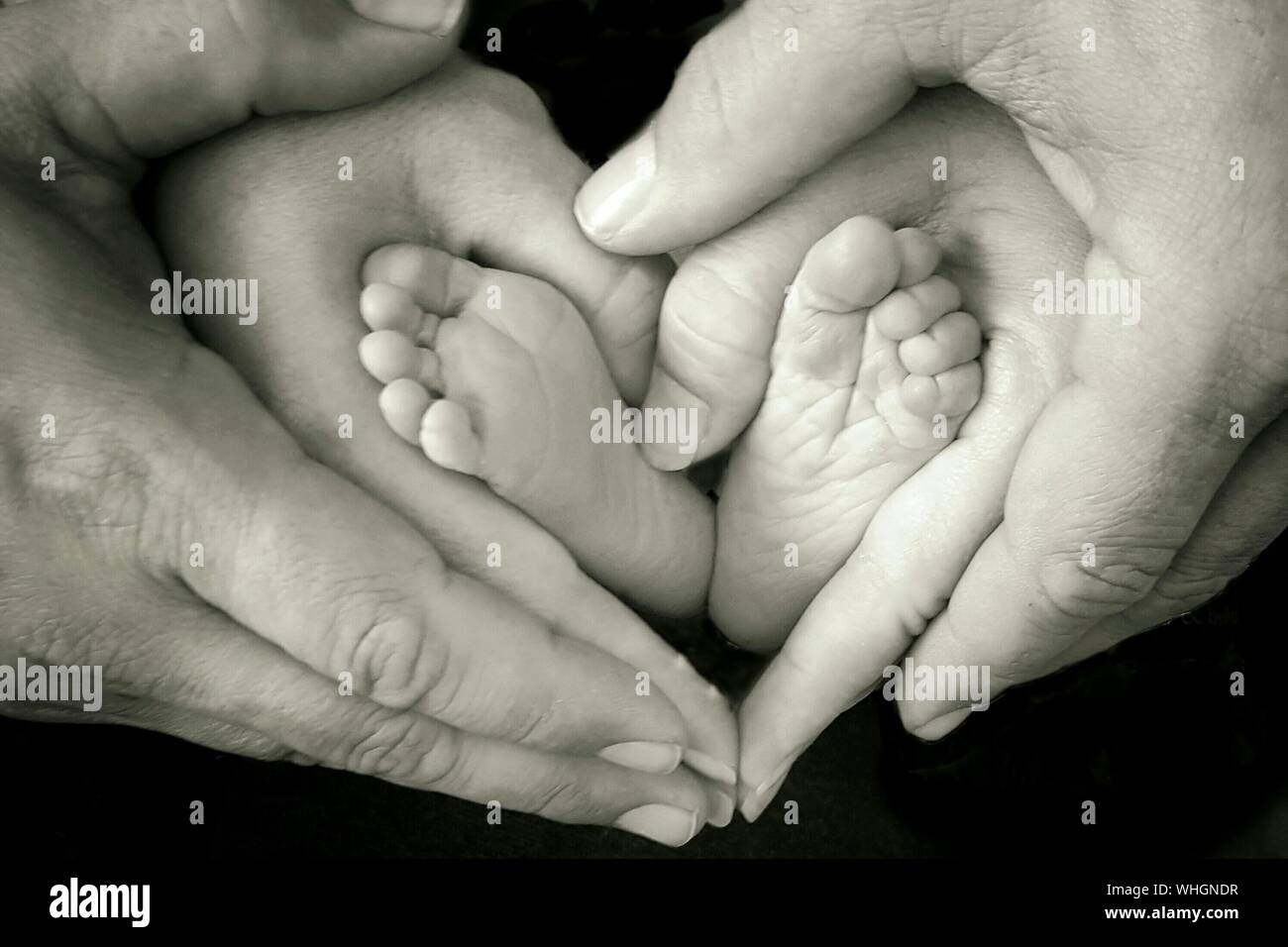 Portrait Des Parents De Faire Forme De Coeur Avec Des Pieds De Bebe Sur Fond Noir Photo Stock Alamy