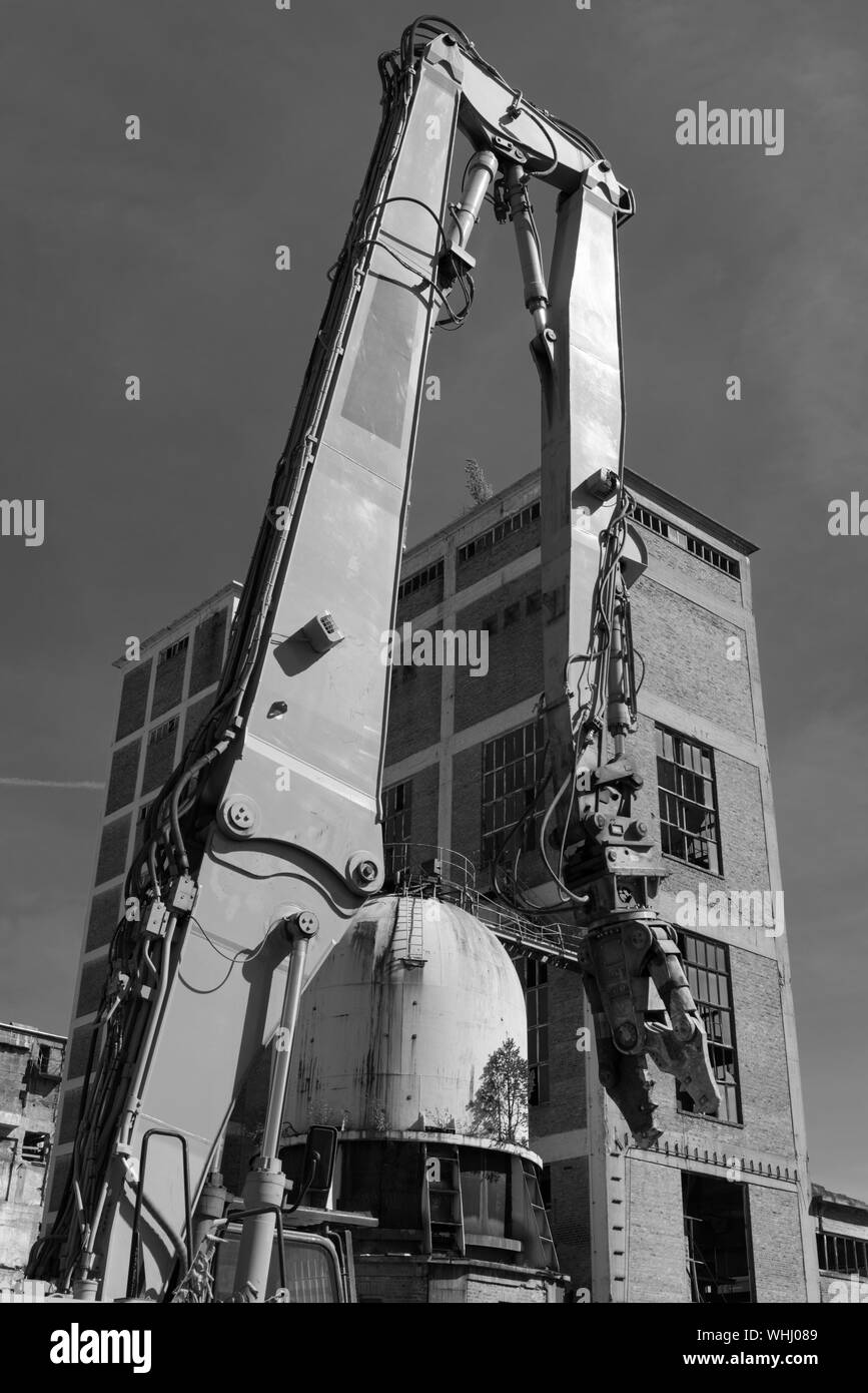 Pinces de démolition sur une pelle mécanique sur un chantier en noir et blanc Banque D'Images
