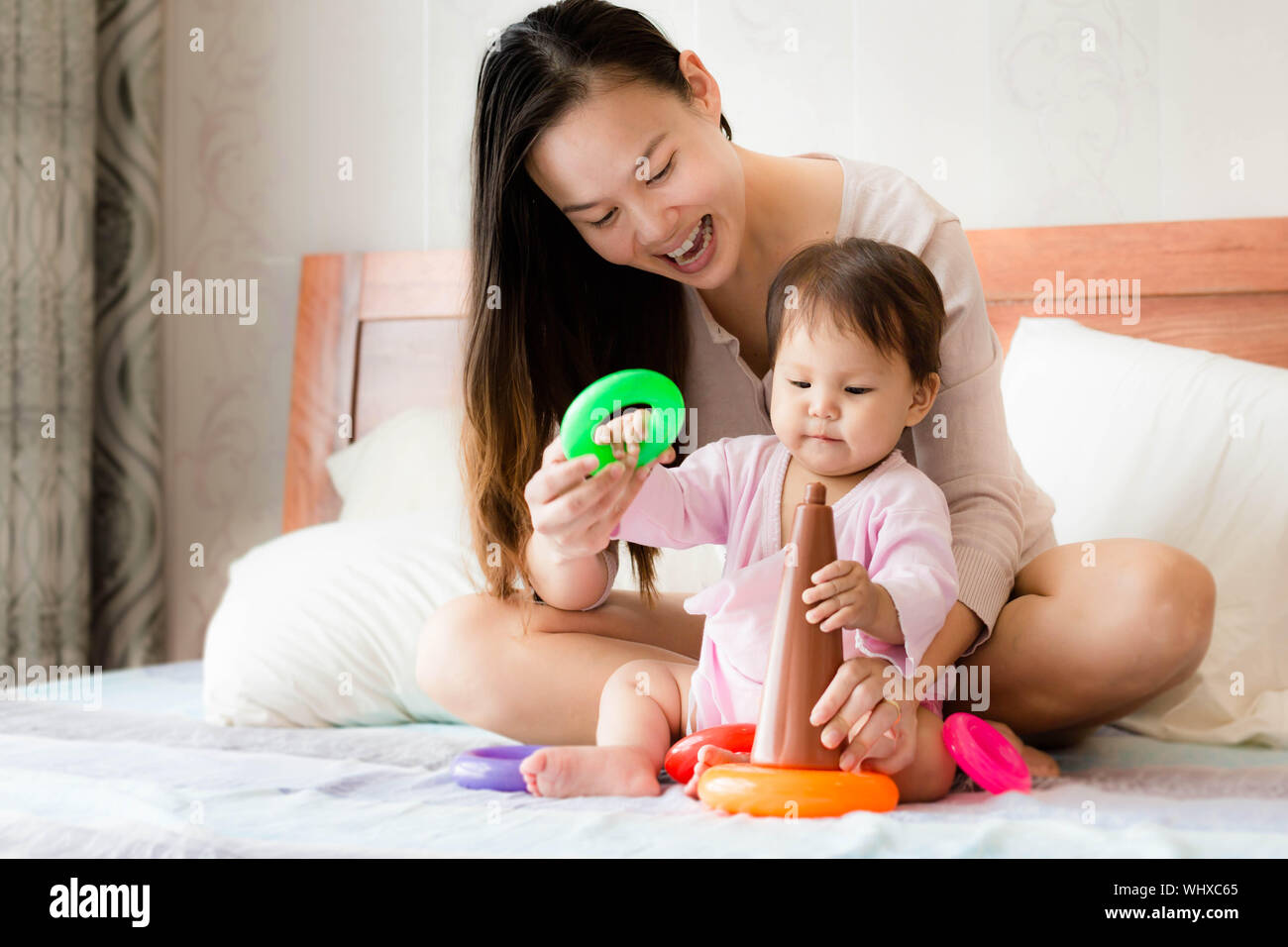 Maman asiatique et caucasienne et fille jouer avec des jouets colorés hoop Banque D'Images