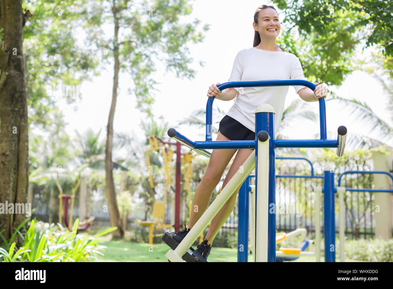 Une jolie femelle adulte de faire un entraînement sur l'équipement du parc à l'extérieur. Banque D'Images