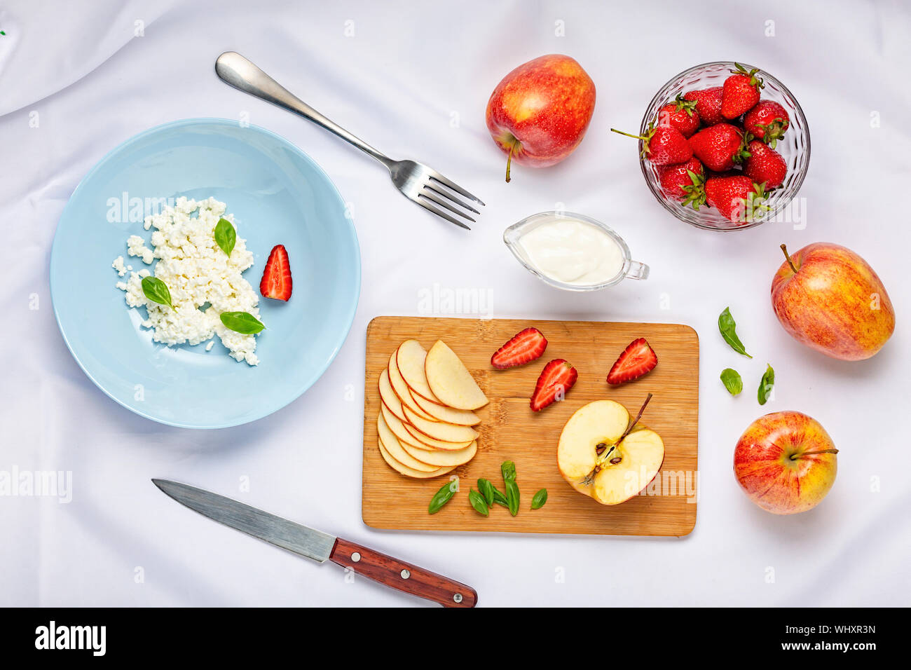 Manger des fraises, bleuets, salade de fruits, gâteau au fromage, crêpes, yaourts, crème, petit déjeuner, coupe de fruits, nappe, faible en gras Banque D'Images