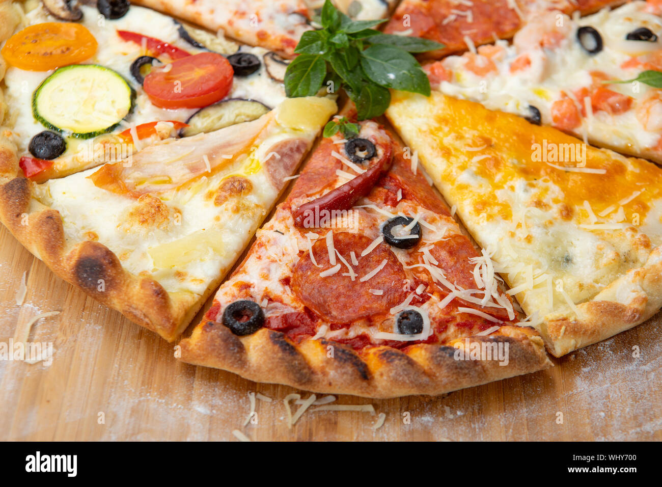 Assortiment de tranches de pizza close-up avec des ingrédients différents décoré avec du basilic, un assortiment de fast food italien traditionnel Banque D'Images