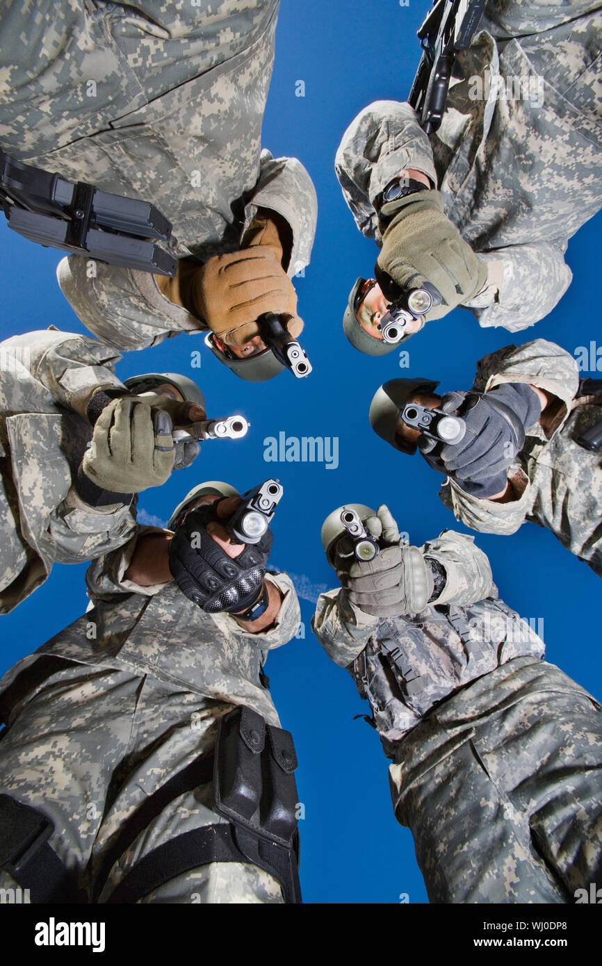 Low angle portrait de soldats debout en cercle, visant Banque D'Images