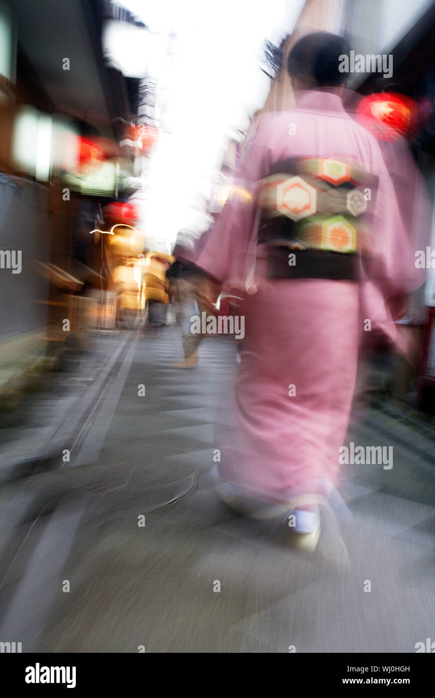 Le Japon, Kyoto, Pontocho-dori, Woman wearing kimono marche sur la rue étroite, le motion blur Banque D'Images