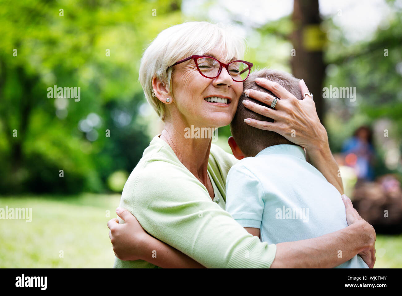 Grand-maman heureuse avec petit-fils embrasser dans un parc en plein air Banque D'Images