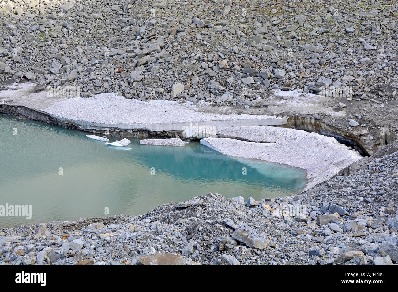 En plaques de glace brisée d'un glacier dans un lac glaciaire dans les montagnes comme le climat se réchauffe. Banque D'Images