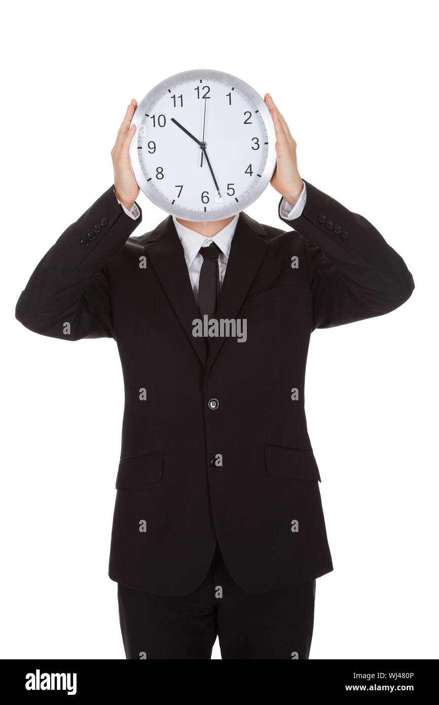 Businessman holding réveil sur le visage. Isolated on white Banque D'Images