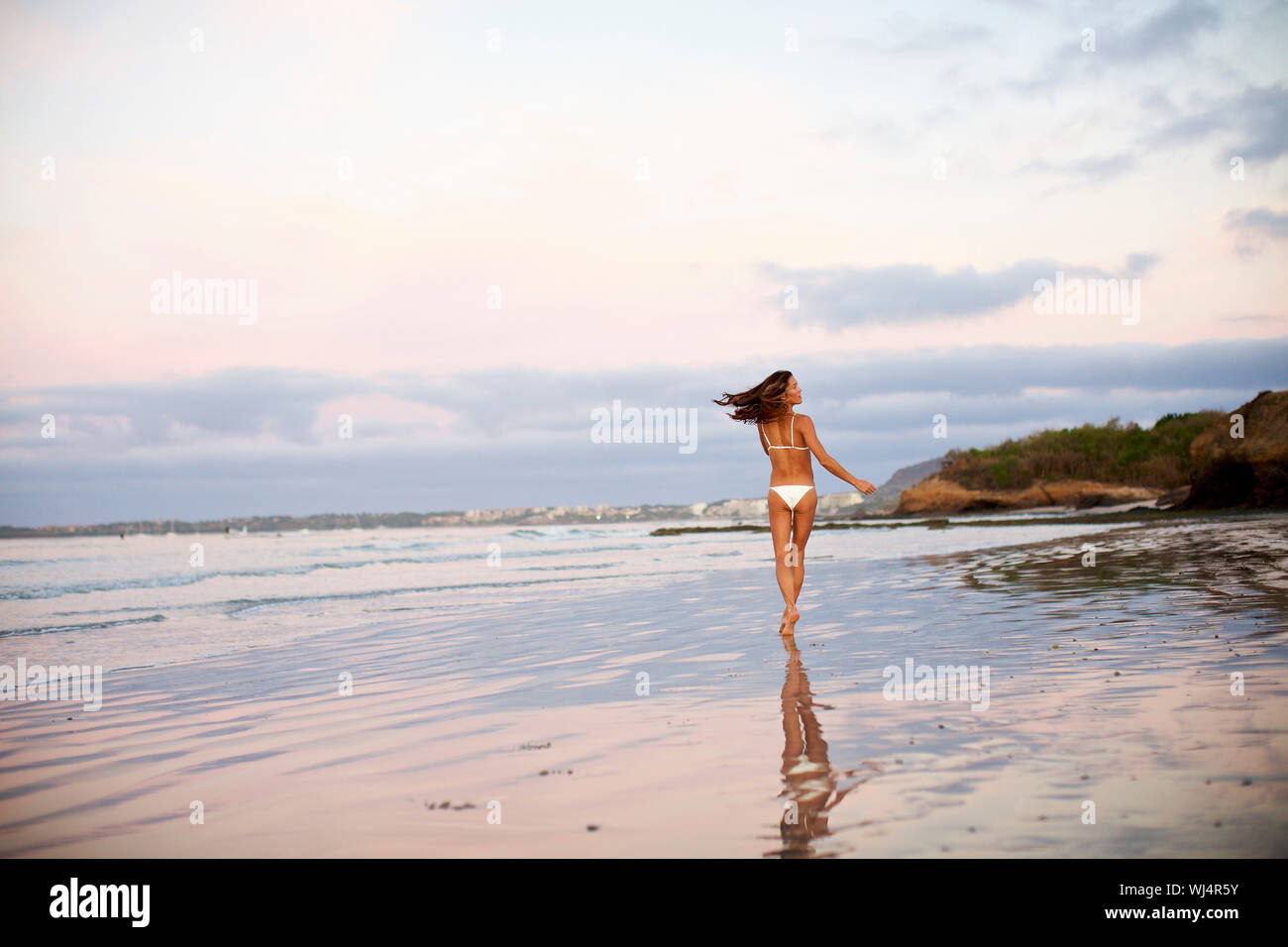 Carefree woman in bikini running on beach, Sayulita, Nayarit, Mexique Banque D'Images