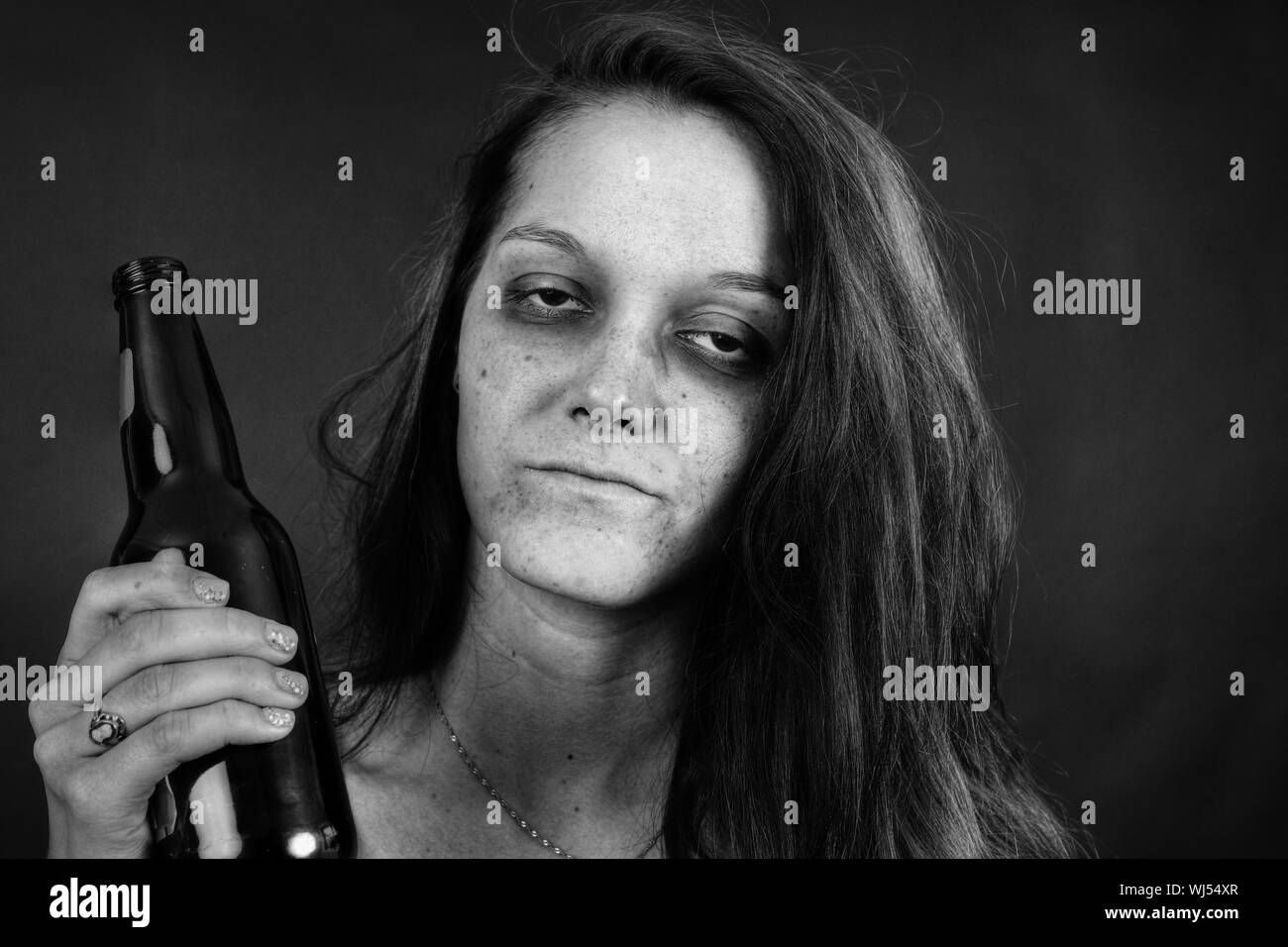 Noir et blanc portrait dramatique d'une jeune femme addict avec bière, junkie, l'alcool ou la toxicomanie. Banque D'Images