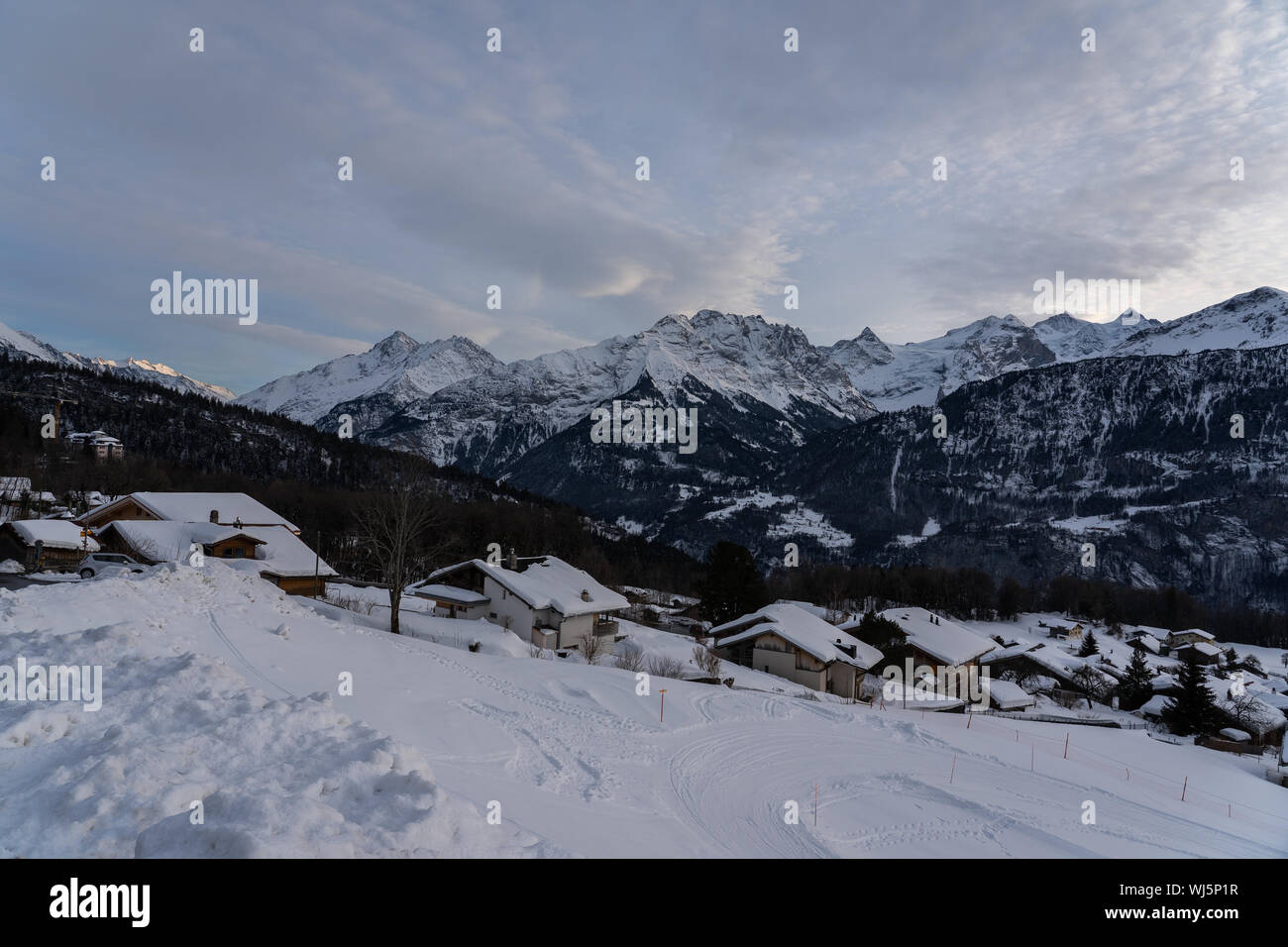 Scène après le coucher du soleil de la tranquillité d'un village de montagne en face d'une montagne enneigée éventail en Suisse. Banque D'Images