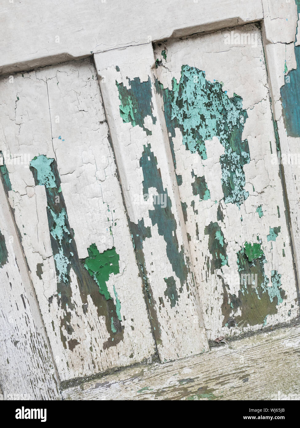 Couches de peinture écaillée sur la vieille porte en bois.Peinture écaillée, craquelures de peinture, vieille peinture, vieille porte décolorée par le temps. Banque D'Images