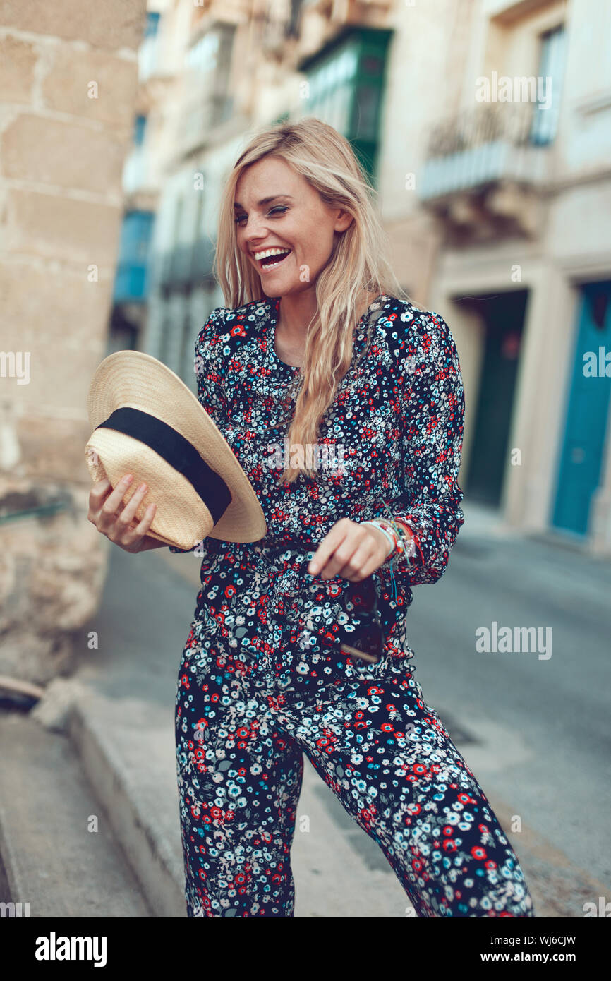 Happy young blonde woman posing à la mode à la rue de la Méditerranée, à rire et à l'écart Banque D'Images