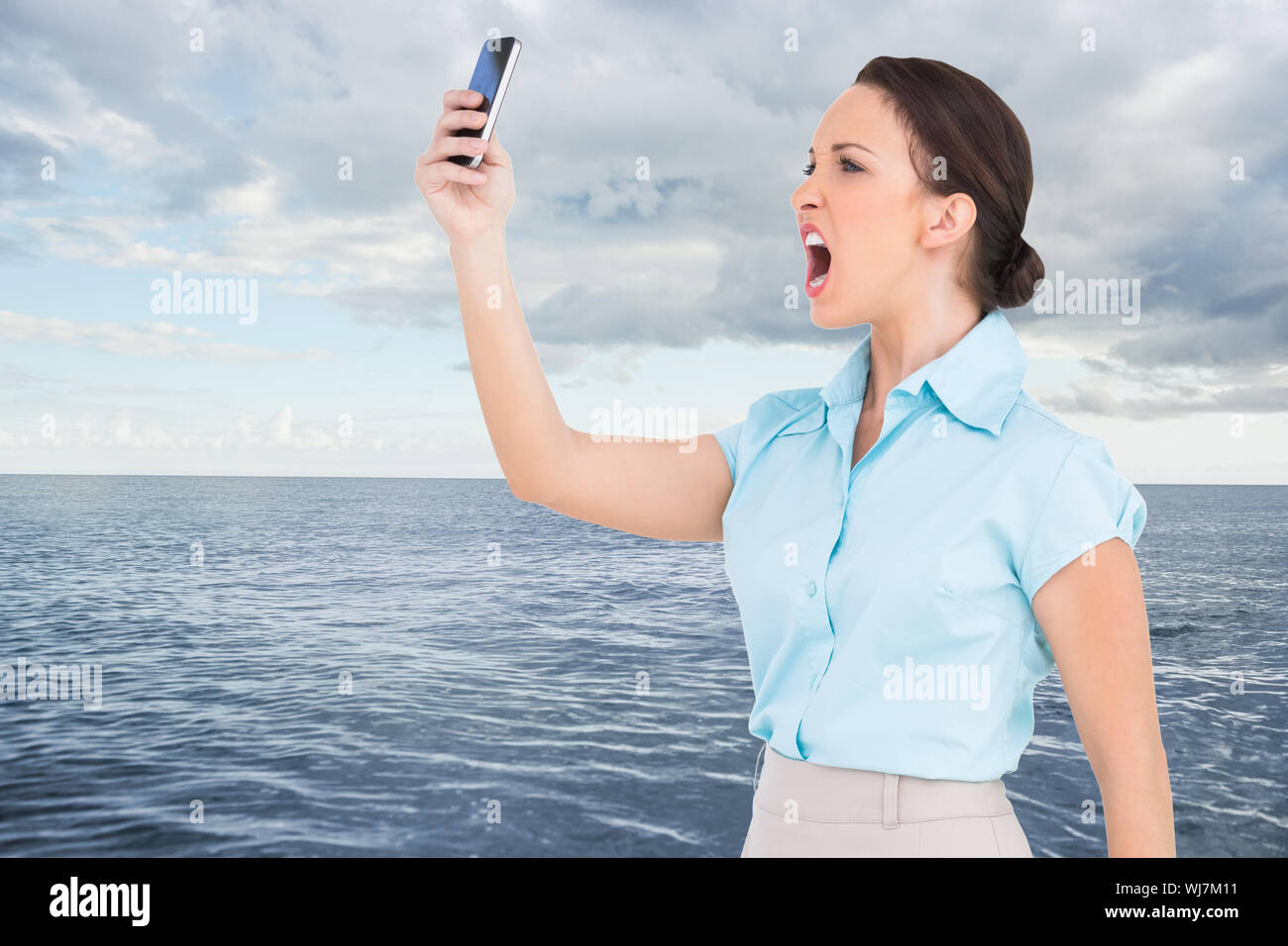 Image composite de angry classy businesswoman yelling at her smartphone Banque D'Images
