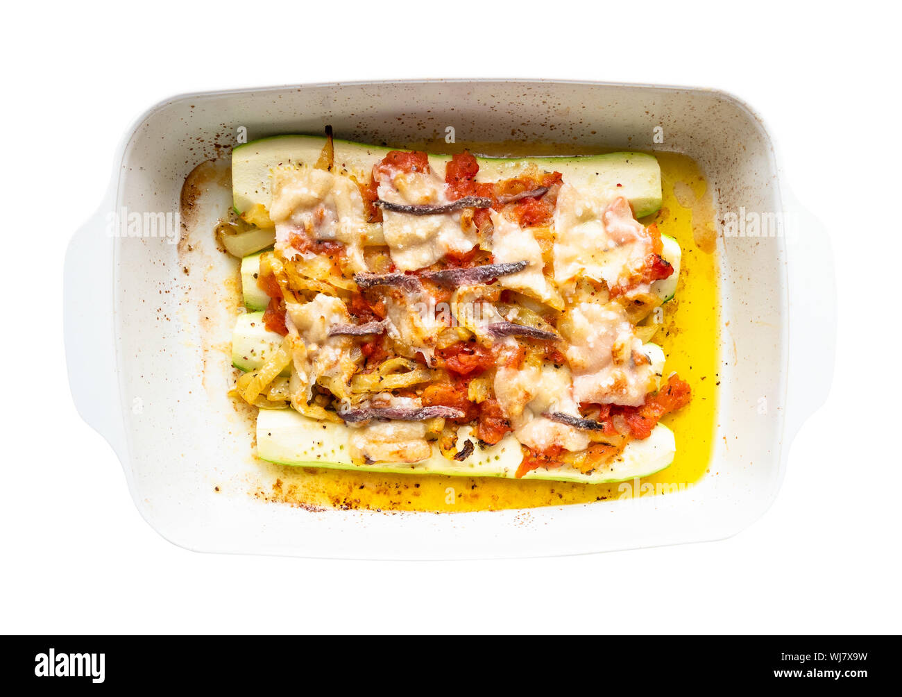 Cuisine française - Vue de dessus de la Courgette cuite au four avec des tranches de tomate et piment doux avec topping de fromage Parmesan, l'ail et les anchois à l'huile d'olive Banque D'Images