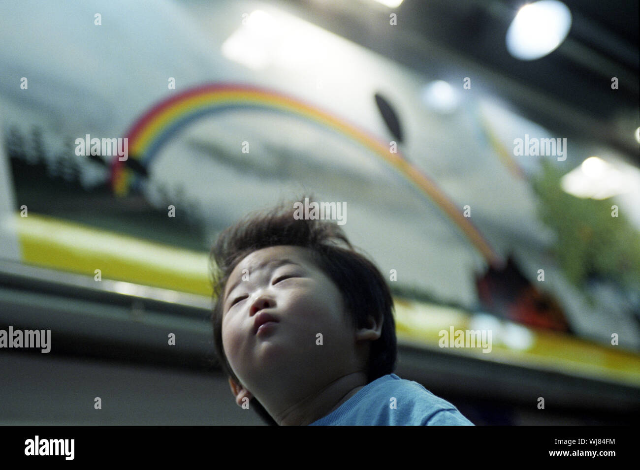 Un jeune garçon est assis sur l'épaule de son père dans le quartier commerçant de Shibuya, Tokyo, Japon. Banque D'Images