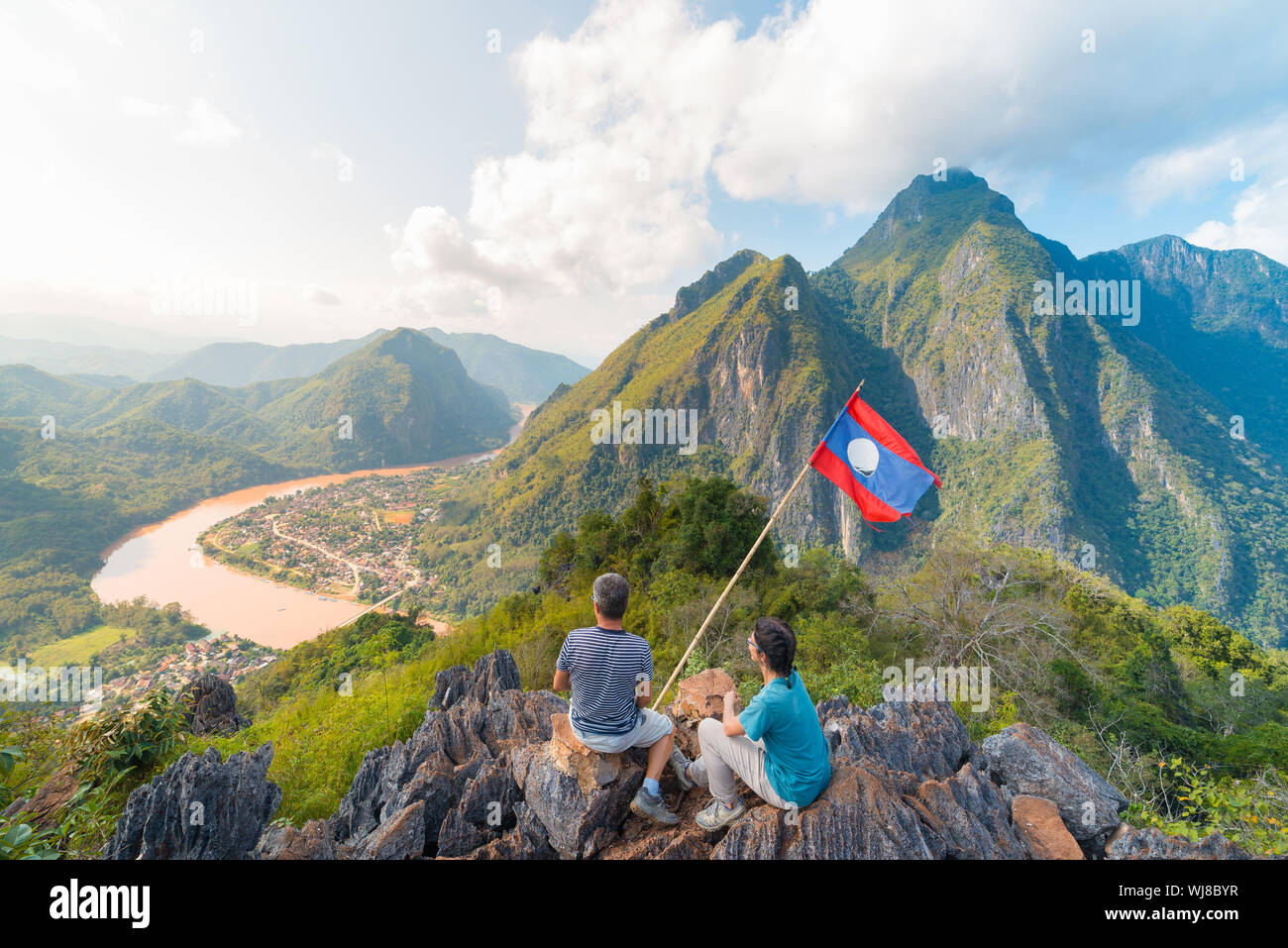 Couple à la conquête de montagne à Nong Khiaw vue panoramique sur la vallée de la rivière Nam Ou au Laos drapeau national scenic mountain landscape célèbre billet destin Banque D'Images