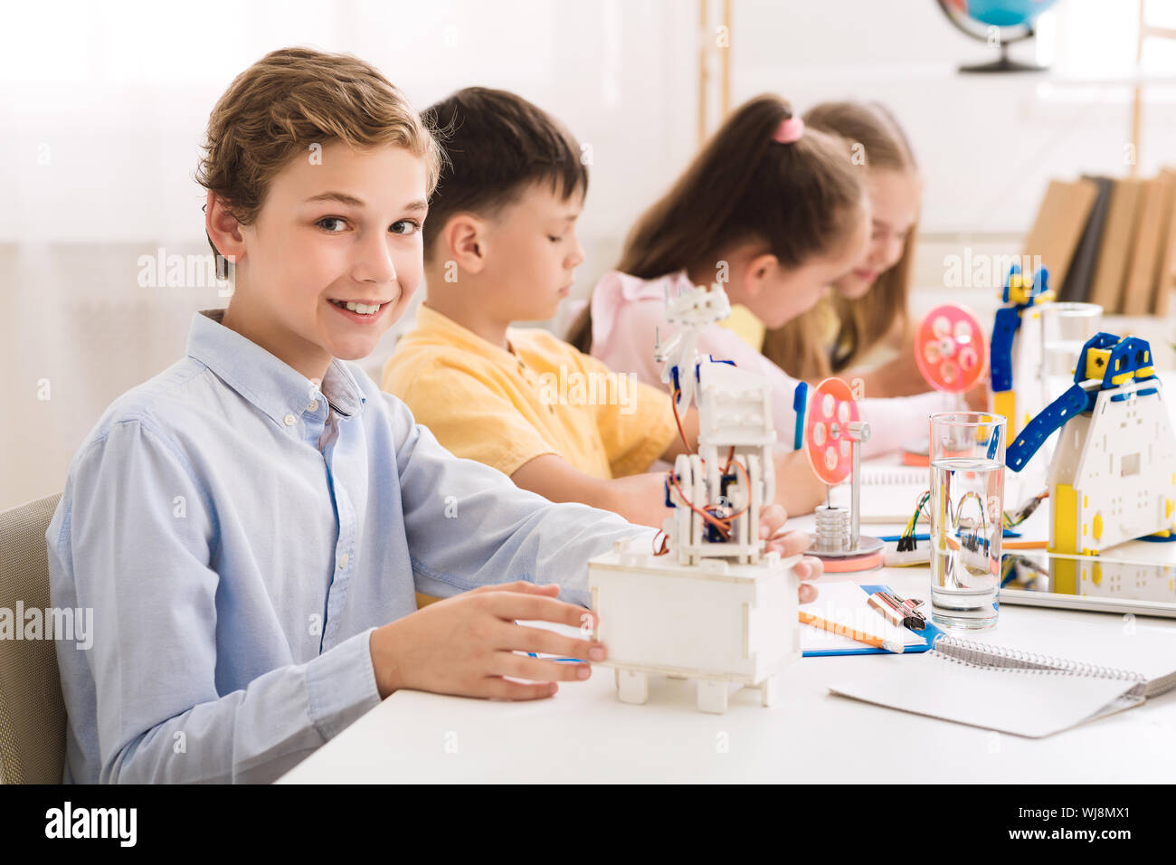 La création d'écolier au robot lab, smiling to camera Banque D'Images