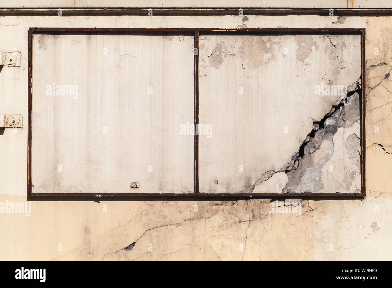 Vieux rouillé vide monté sur châssis publicité grungy mur de béton avec des fissures, la texture de fond photo Banque D'Images