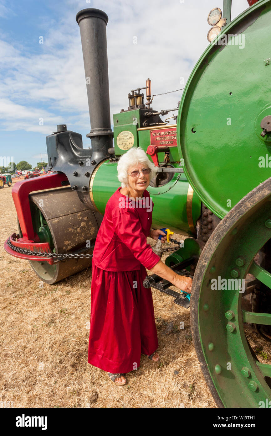 Polissage de dernière minute d'un Aveling & Porter road roller par une dame d'âge mûr à la basse Ham 2018 Rallye à vapeur, Somerset, England, UK Banque D'Images