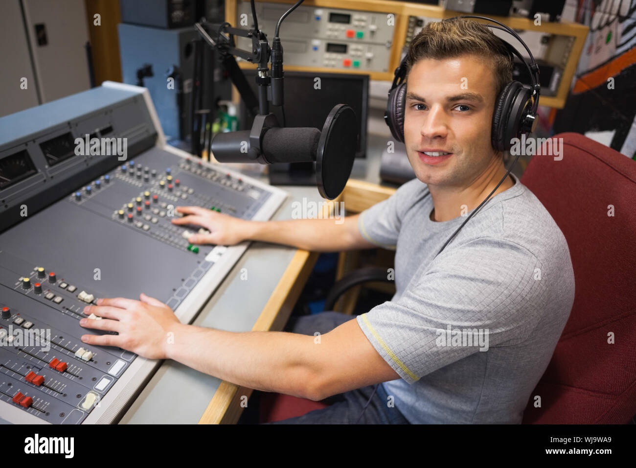 Handsome smiling watching TV en studio au college Banque D'Images