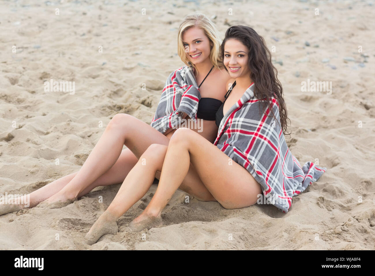 Portrait de deux jeunes femmes couvertes de couverture à la plage Banque D'Images