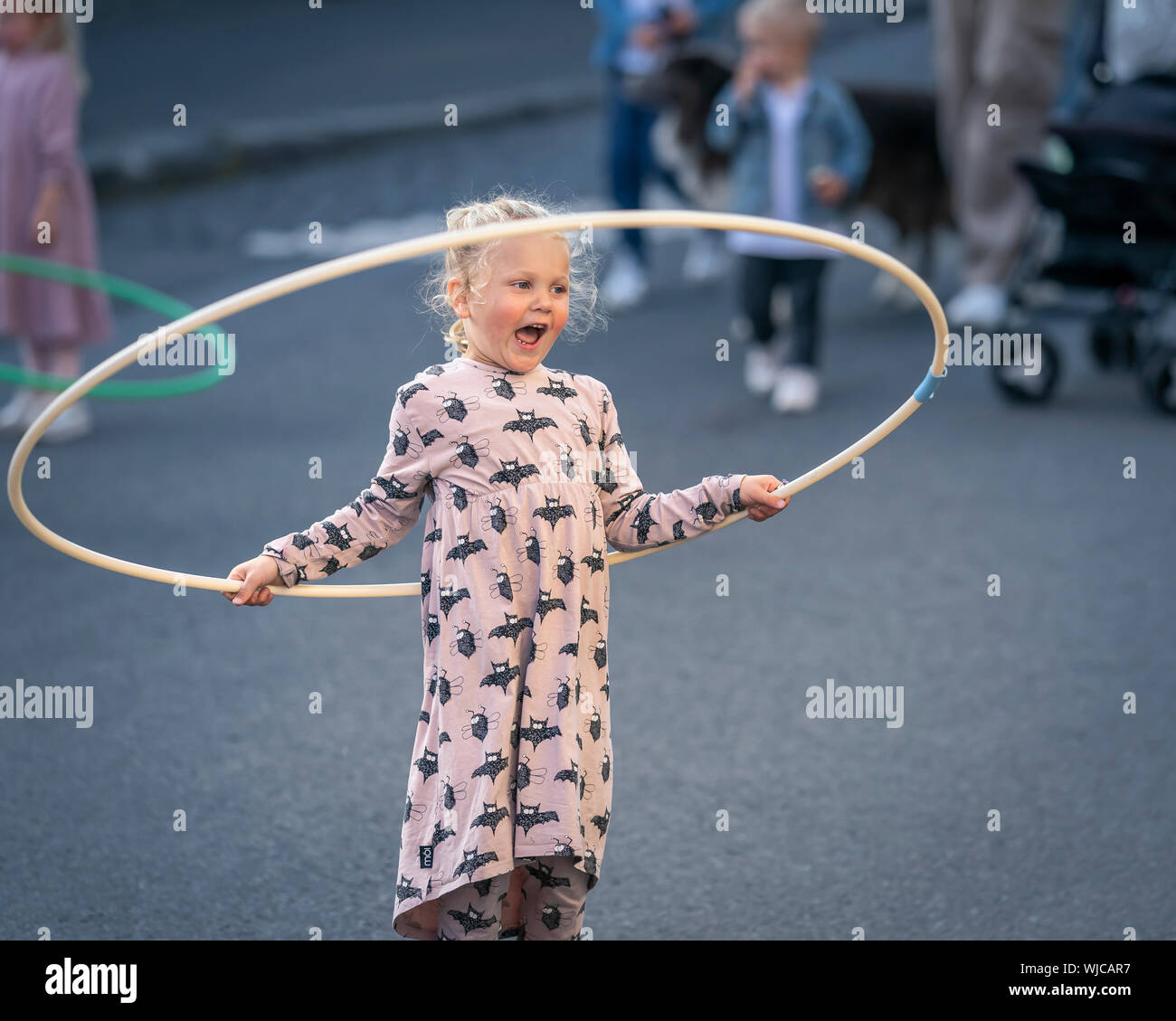 Les enfants jouent avec des cerceaux, Menningarnott ou culturel 24, Reykjavik, Islande. Rue fermée hors de voitures. Banque D'Images