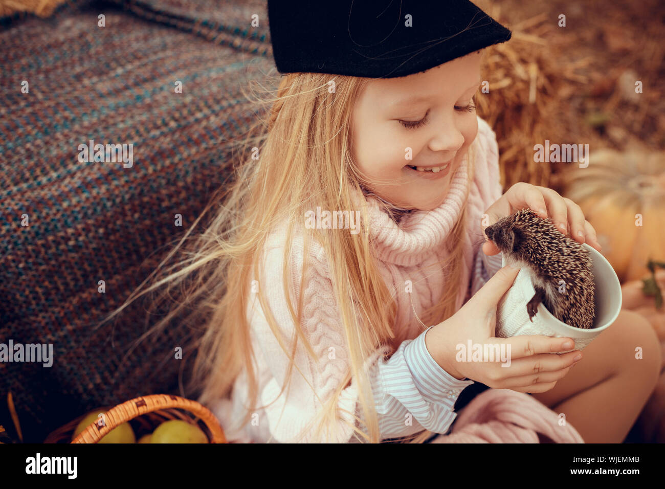 Belle Petite Fille Avec Bebe Herisson Mignon Et Drole En Automne La Nature Avec Des Citrouilles Et De Paille Tenant Une Tasse De Boisson Chaude Photo Stock Alamy