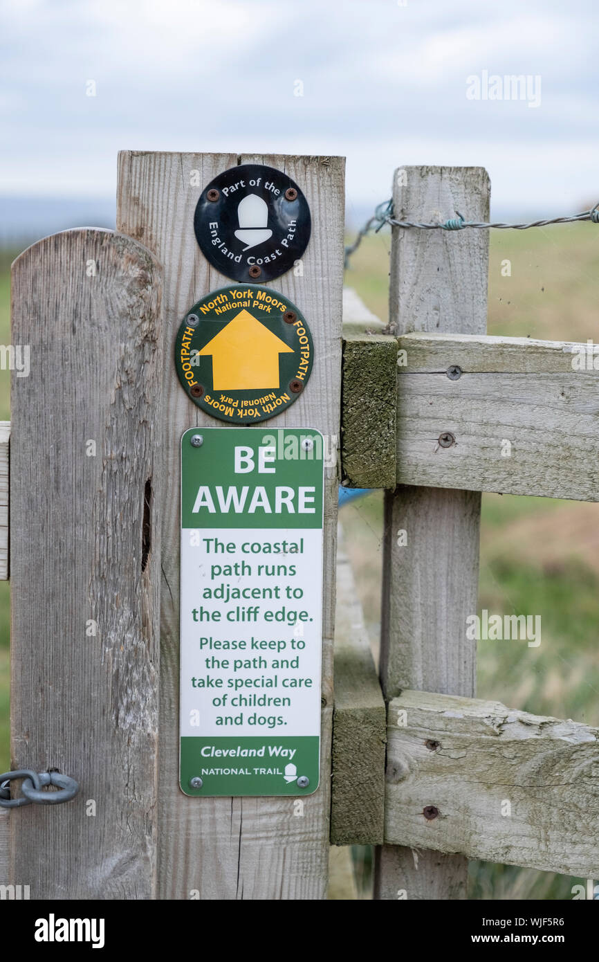Direction et des panneaux d'avertissement sur le Cleveland Way, près de Staithes, North Yorkshire, Angleterre. Banque D'Images