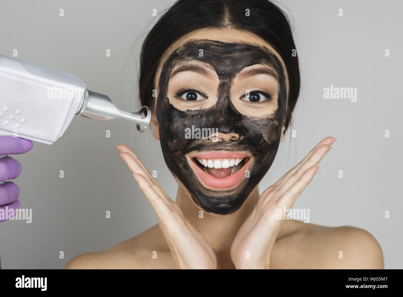 Femme Asiatique avec masque noir sur le visage surpris, emotionon avec procédure de publicité peel carbone Banque D'Images