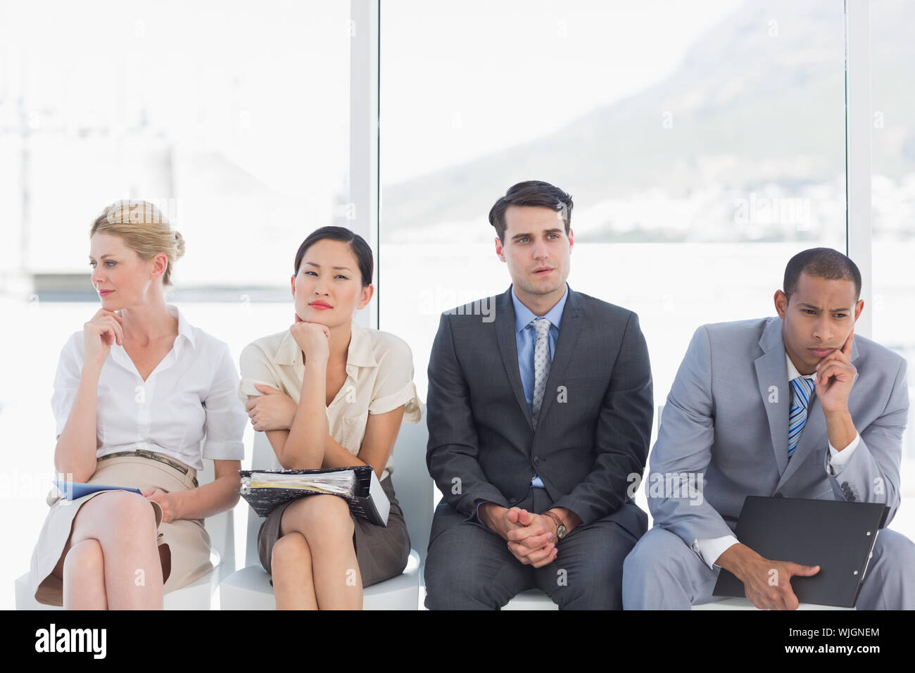 Quatre personnes en attente d'entrevue d'emploi dans un bureau lumineux Banque D'Images