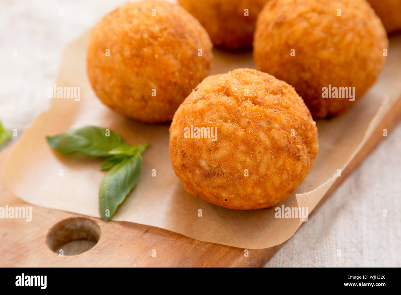 Frites maison Arancini au basilic sur une planche de bois rustique, vue de côté. Boules de riz italien. Libre. Banque D'Images