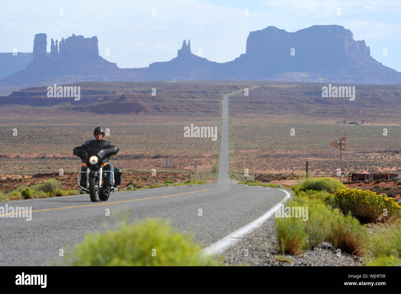 Manèges une Harley-Davidson le long de la célèbre Route panoramique U.S163, Monument Valley sur la frontière de l'Utah, Arizona USA Banque D'Images