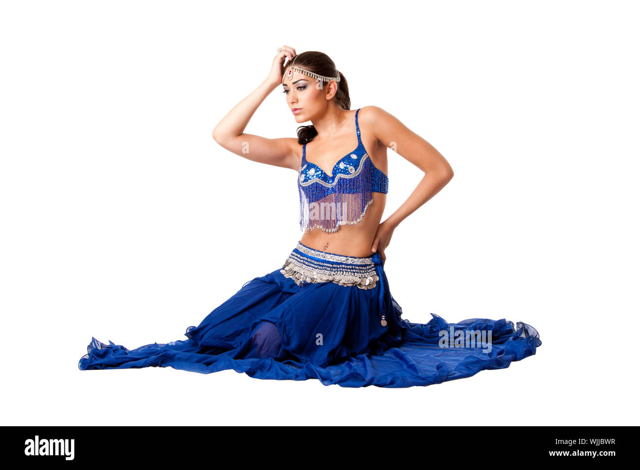 Belle libanaise égyptienne israélienne Middle Eastern fashion ventre danseuse interprète dans jupe bleue et soutien-gorge avec main tenant tête, isolé. Banque D'Images