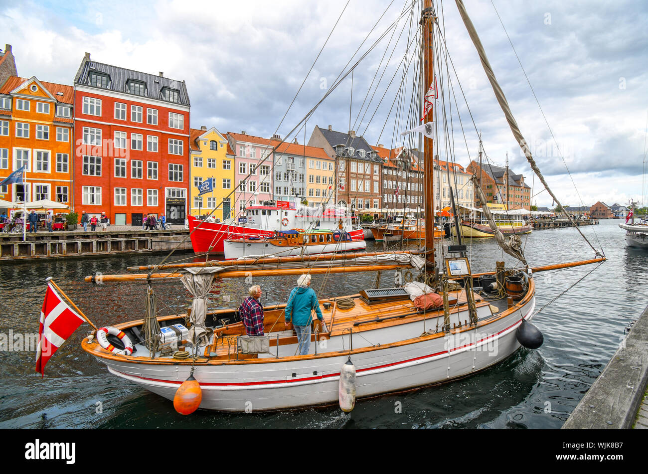 Un homme et une femme leur dock voilier sur le canal sur l'image dans le 17e siècle colorés de Nyhavn à Copenhague, Danemark. Banque D'Images