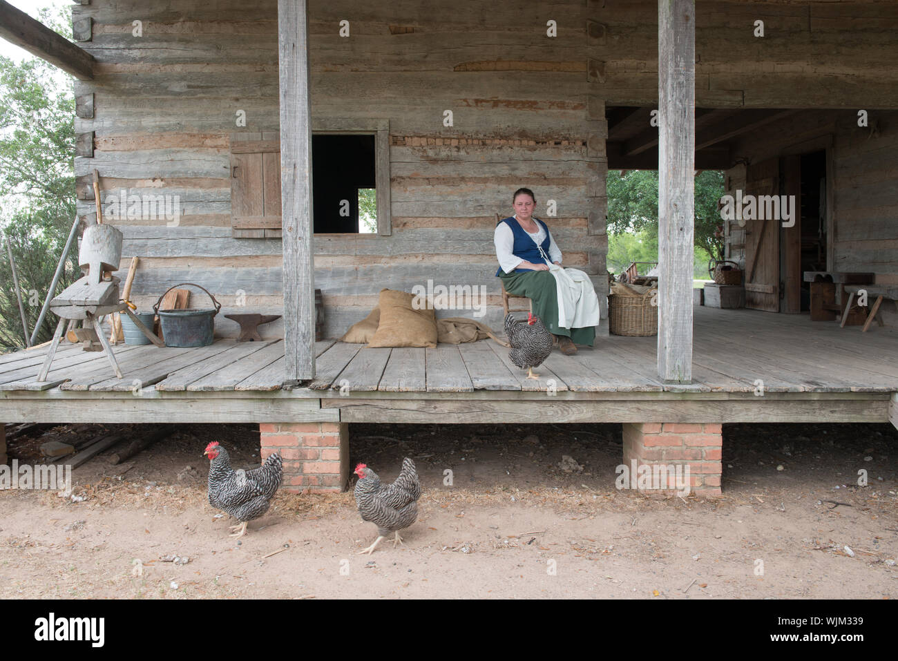 Tina interprète historique Griffith sur le porche de la ferme de stock à la George Ranch Historical Park, un 20 000 acres ranch dans le comté de Fort Bend, Texas, avec ses demeures historiques, des interprètes en costume d'époque et de l'élevage. Un stock farm est le ranch de travail d'un éleveur de bétail et éleveur Banque D'Images