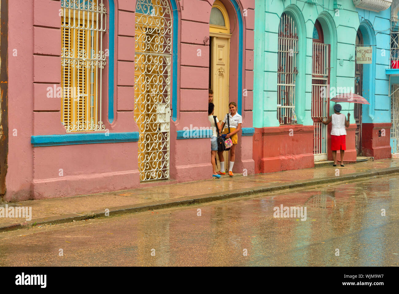 La photographie de rue dans le centre de La Havane- réflexions dans la chaussée mouillée sur un jour de pluie avec passants, La Habana (La Havane), La Havane, Cuba Banque D'Images