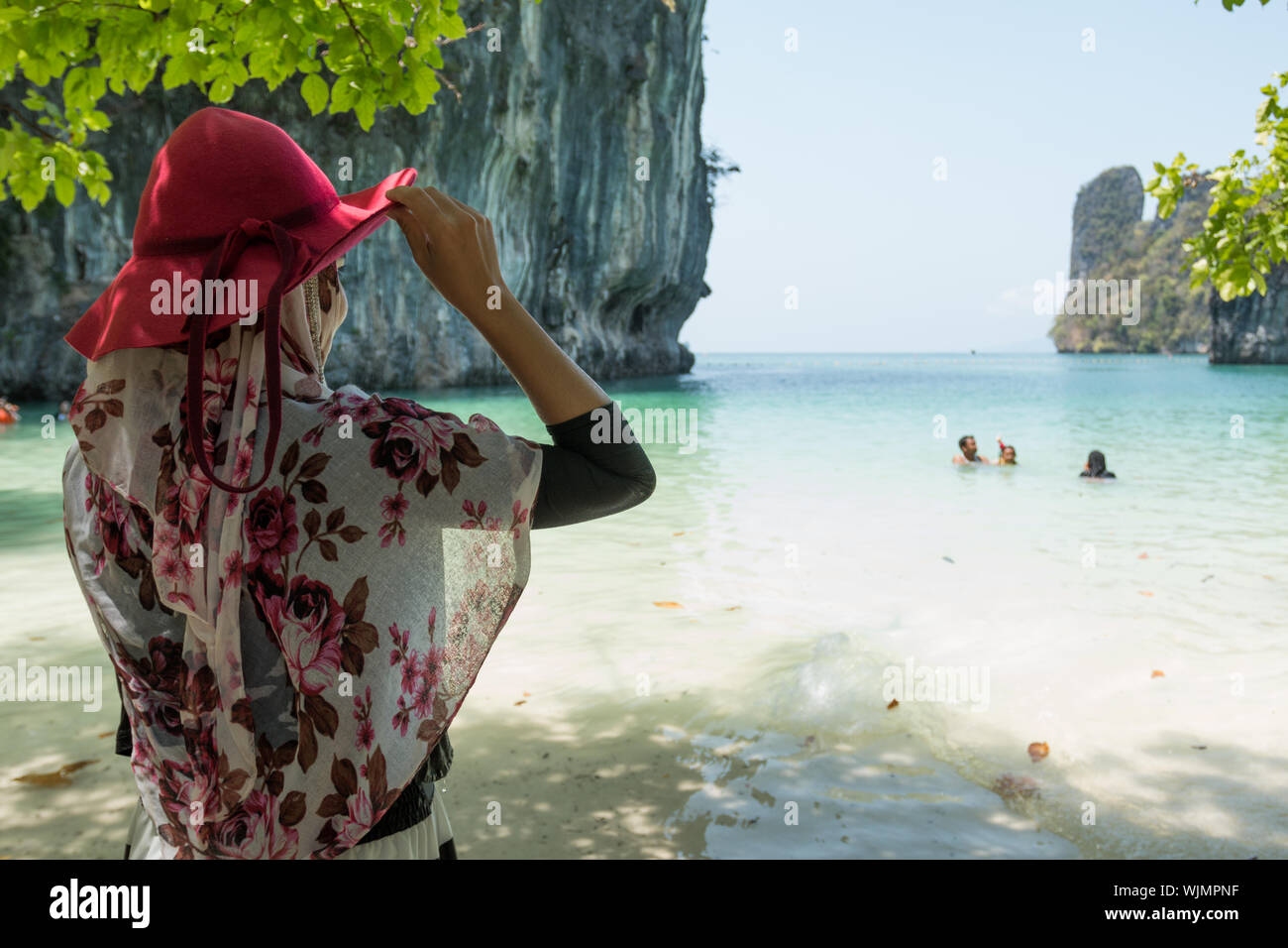 Rear View of Woman With Red Hat Standing At Beach Banque D'Images