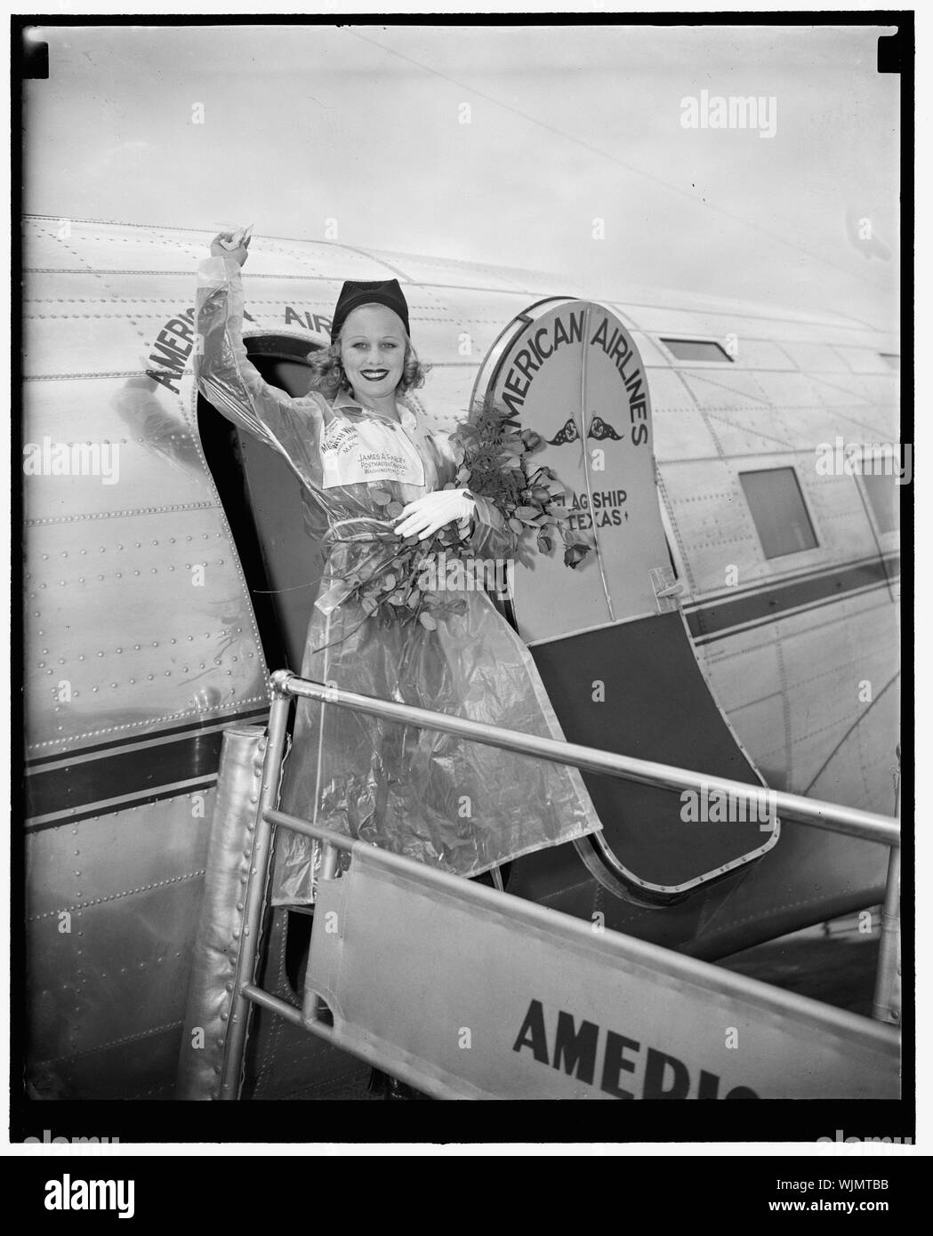 Starlette hollywoodienne arrive à participer à la Semaine nationale de la poste aérienne. Washington, D.C., le 15 mai. Mlle Marion Weldon, Paramount starlet, vagues une salutation à la foule qu'elle est arrivée à l'aéroport de Washington aujourd'hui pour participer à la Semaine nationale de la poste aérienne en tant que représentant de la ville de film. Mme Weldon a été sélectionné pour l'honneur par les 22 pilotes et cascadeurs qui ont comparu avec elle dans la prochaine production technicolor primordiale hommes avec des ailes, 5/15/38 Banque D'Images