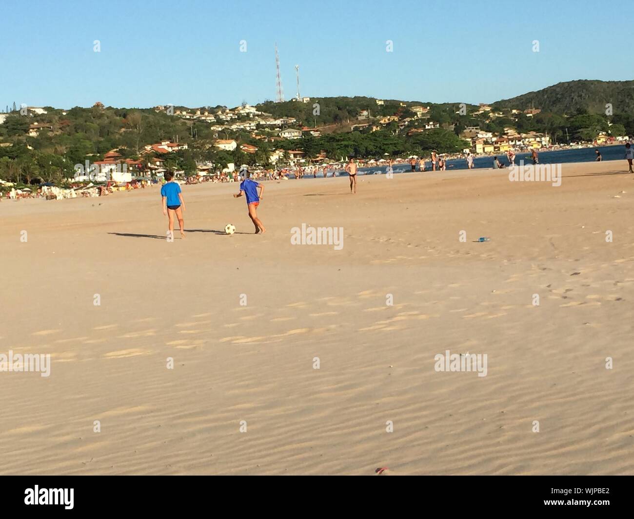 Les enfants jouent au football sur la plage Banque D'Images