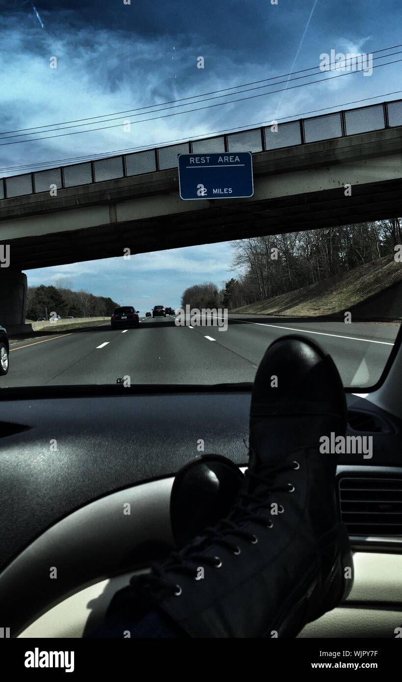 La section basse de la personne les jambes sur le tableau de bord